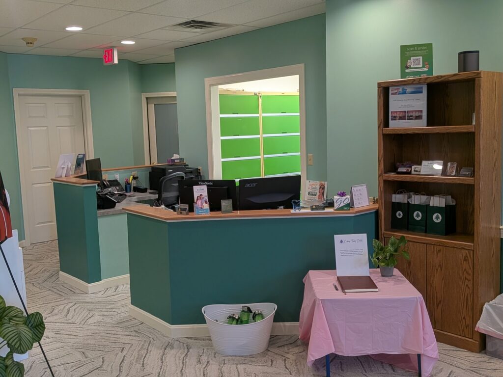 The front desk at Cedars Family Dental, with a bookshelf of patient information beside it