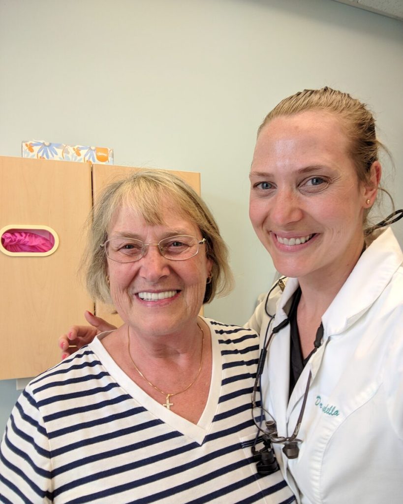 Dr. Allie Barbosa smiling beside an older family member in the office