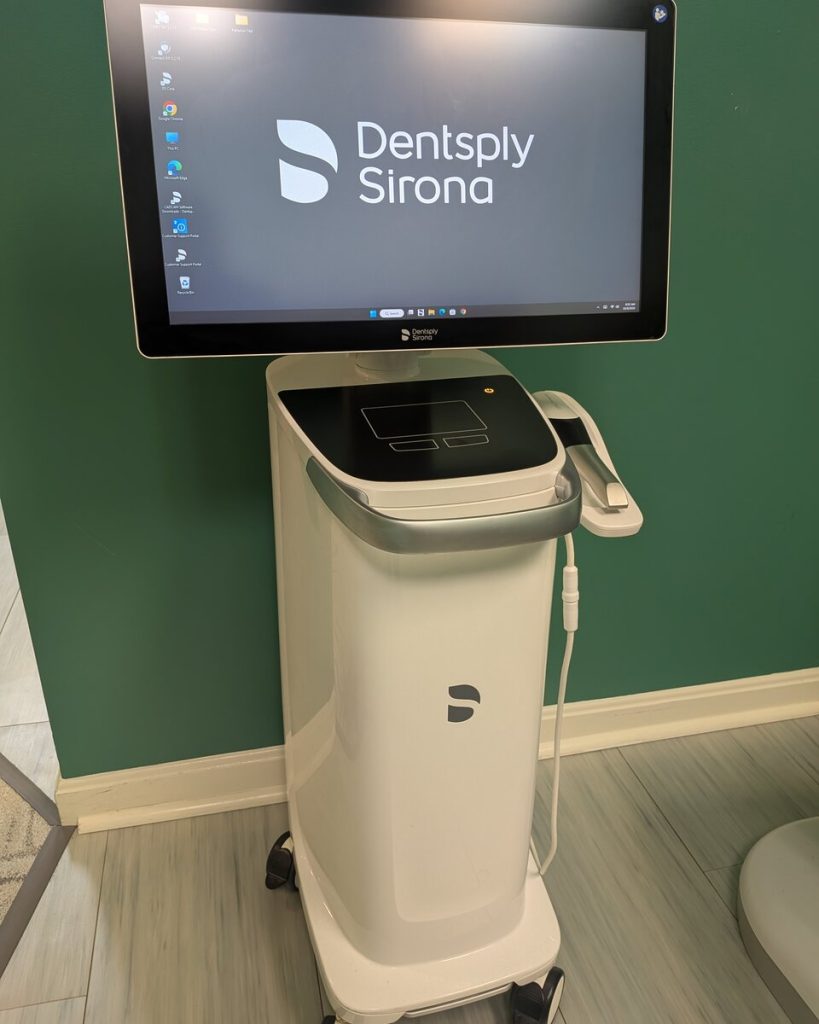 The office's Dentsply Sirona intraoral scanner on its wheeled cart, its screen above
