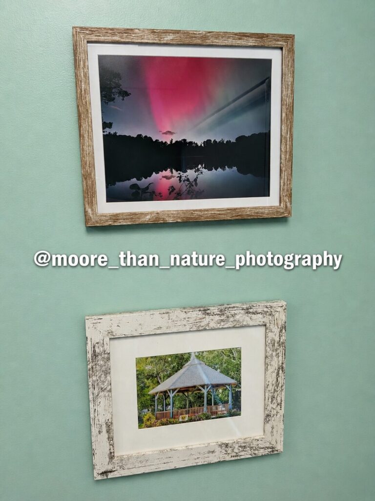 Two framed photographs: the northern lights over a still lake, and a garden gazebo